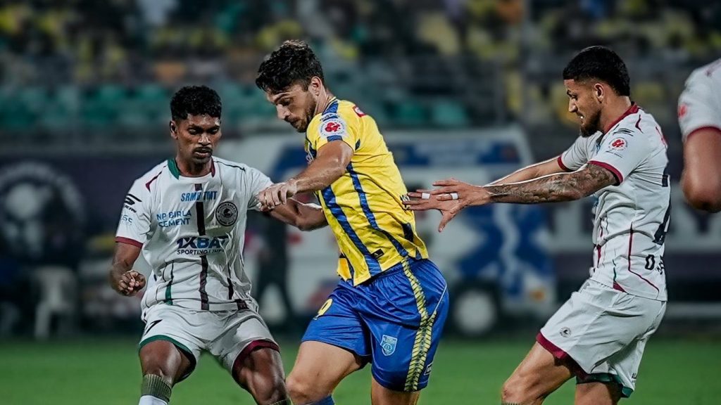 Kerala Blasters striker Jesus Jimenez contesting for the ball against Mohun Bagan midfielder Deepak Tangri and Liston Colaco. 